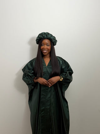 Person wearing a dark green Bubu gown and matching green headband against a plain background